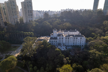The aerial perspective reveals a contemporary building nestled among vibrant trees in Sao Paulo, highlighting the blend of nature and urban development in the city.の写真素材