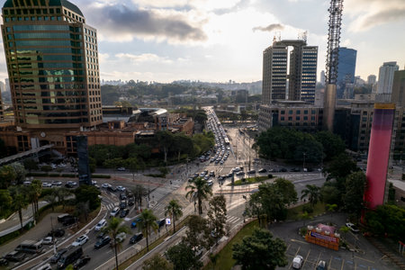 The bustling Shopping Market Place in SÃ£o Paulo is visible from above, highlighting its contemporary architecture amid lush greenery and urban surroundings, with vehicles navigating the area.の写真素材