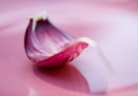 Isolated garlic on rose plate in the kitchen ready to be used in culinarie