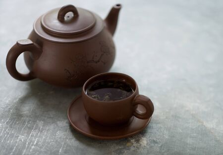 Wooden teapot with wooden cup full of aromatic tea