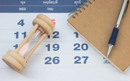 A book with a pen and the hourglassの写真素材