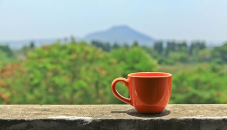Coffee cup orange mountain backdrop.の写真素材