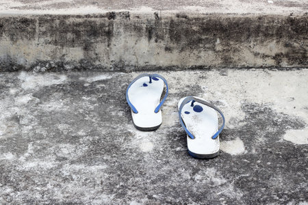 Old slippers on the cement floor,Old slippers in vintage picture styleの写真素材