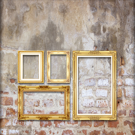 gold antique picture frame on the old brick wall backgroundの写真素材