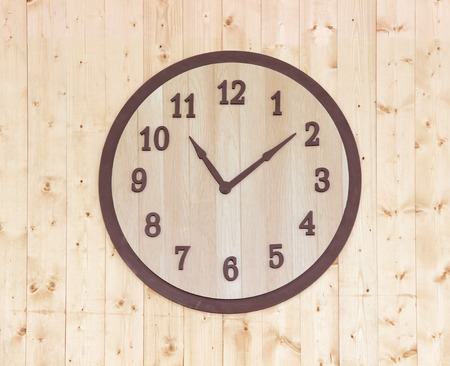 wooden clock on wooden wall background