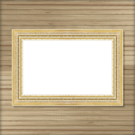 Antique gold frame on wooden wall ;. Empty picture frame on wooden wall.の写真素材