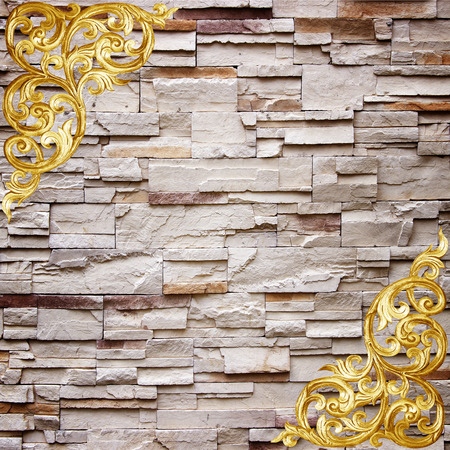 Pattern of wood carve flower on stone wall background ,Pattern of wood carve flower frame on sandstone Brick Wall Surfaced backgroundの写真素材