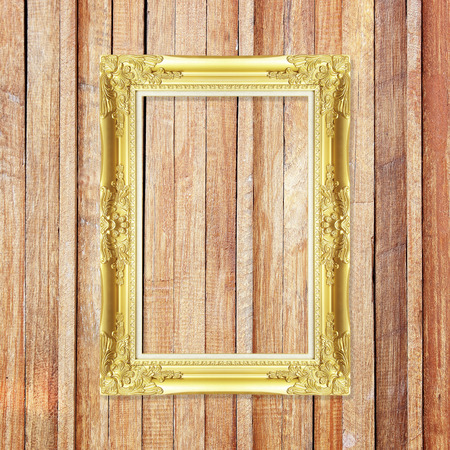 Antique gold frame on wooden wallの写真素材
