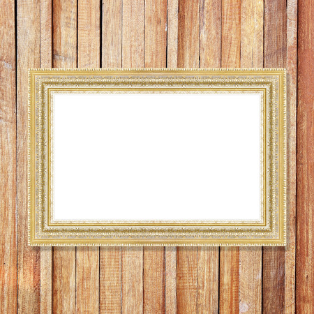Antique gold frame on wooden wall ;. Empty picture frame on wooden wall.の写真素材