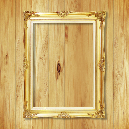 Antique gold frame on wooden wall ;. Empty picture frame on white wooden wall.の写真素材