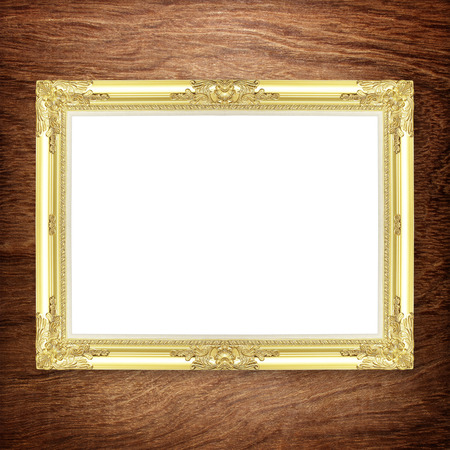 Antique gold frame on wooden wall ;. Empty picture frame on white wooden wall.の写真素材