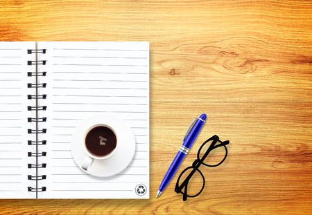 notebook with pen and glasses isolated on woodの写真素材
