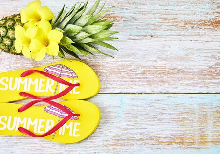 Summer vacation concept, yellow flip-flops with pineapple on a wooden background. Top view, Summer fashion.の写真素材