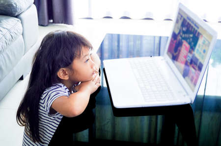 A Girl studying lesson online  from home on laptop. social distance during quarantine, self-isolation, online education concept.の写真素材