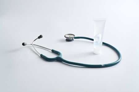 A stethoscope with a hands cleaning. Gel plastic tube to prevent virus infection for prevent covid-19. Space for text on white background.の写真素材