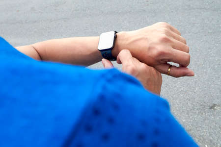 Portrait of a young man in sportswear using his smart watch after training.