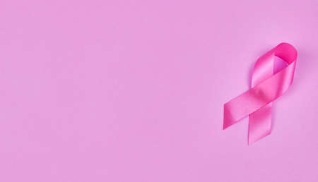 Breast cancer awareness pink sign symbol with face mask on isolated pink background. healthcare and medicine concept.の写真素材