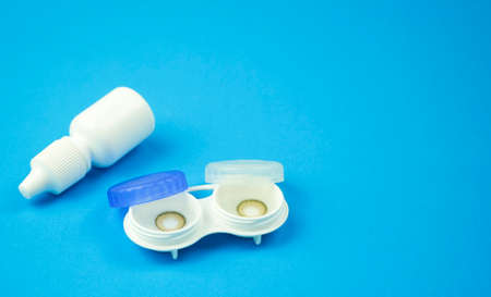 Brown contact lenses into container on blue background, Contact lens, Copy Space for text,の写真素材