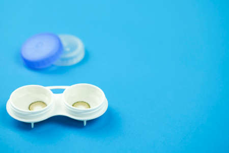 Brown contact lenses into container on blue background, Contact lens, Copy Space for text,の写真素材