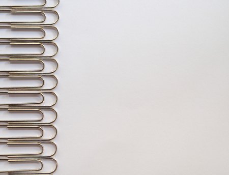 Silver paper clips on a white background with free text spaceの写真素材