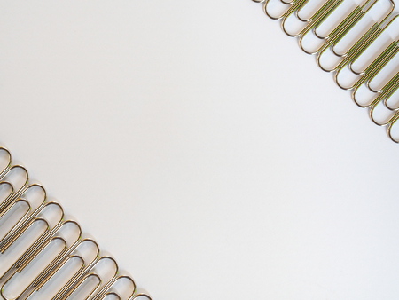 Silver paper clips on a white background with free text spaceの写真素材