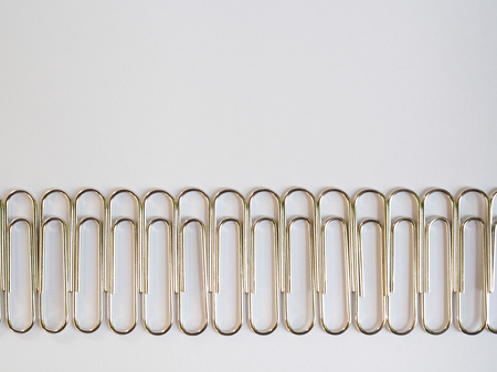 Silver paper clips on a white background with free text spaceの写真素材