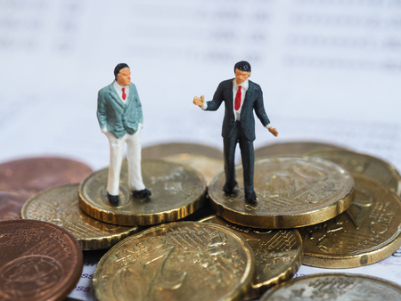 Miniature businessman stand on Euro coins and book bank. Business and idea conceptの写真素材