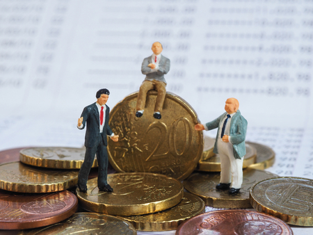 Miniature businessman stand on Euro coins and book bank. Business and idea conceptの写真素材