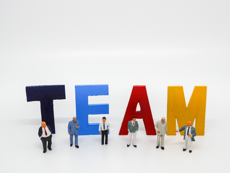 Miniature bussinessman with TEAM word letters on white background, business concept.の写真素材