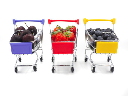 Fresh summer fruits, Cherry, strawberry, and blueberry in shopping cart or trolly isolated on white background.の写真素材