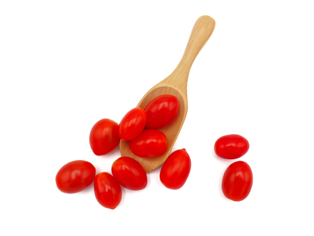 Fresh grape or cherry tomato with wooden spoon on white background.の写真素材