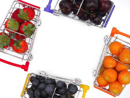 Fresh summer fruits, Cherry, strawberry, cape gooseberry and blueberry in shopping cart or trolly isolated on white background.の写真素材