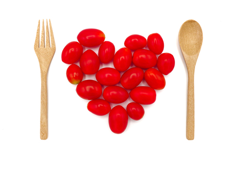 Fresh grape or cherry tomato with wooden spoon on white background.の写真素材