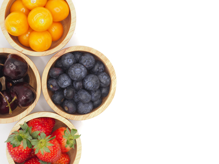 Fresh summer fruits, Cherry, strawberry, cape gooseberry and blueberry in wooden bowl isolated on white background.の写真素材
