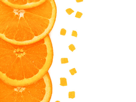 Fresh orange slice and small pieces on white background, with copy or free space for text.の写真素材