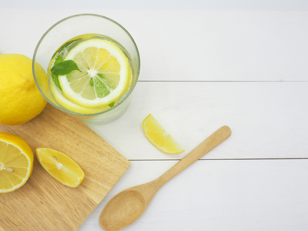 Fresh lemon in water and lemon slice on white wood backgroundの写真素材