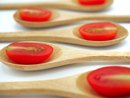 Fresh grape or cherry tomato with wooden spoon on white background.の写真素材