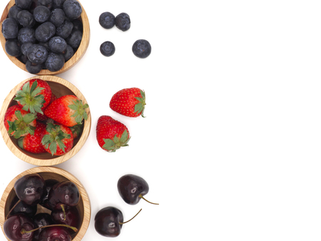 Fresh summer fruits, Cherry, strawberry, and blueberry in wooden bowl isolated on white background.の写真素材