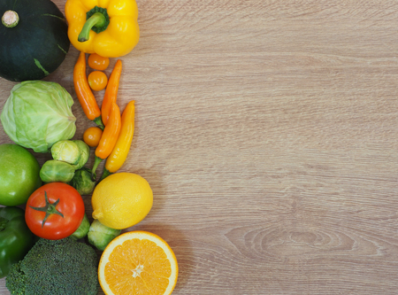 Colorful fresh fruits and vegetables on wood background, healthy eating concept.の写真素材