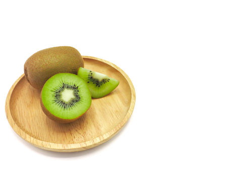 Slice of fresh juicy delicious and healthy kiwi fruit on wooden plate, isolated on white background.の写真素材