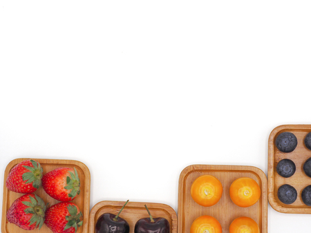 Fresh summer fruits, Cherry, strawberry, cape gooseberry and blueberry in wooden plate isolated on white background.の写真素材