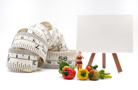 Miniature thin woman with vegetables and measuring tape on white background,  Healthy lifestyle concept.の写真素材