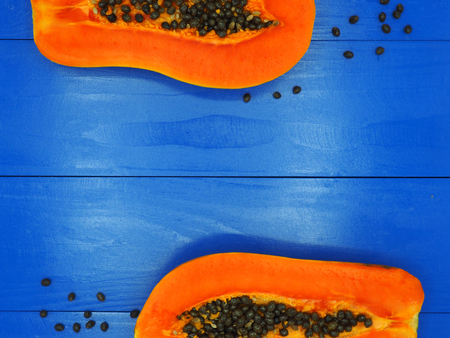 Fresh sliced half papaya isolated on blue wood background.の写真素材