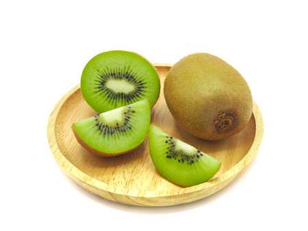 Slice of fresh juicy delicious and healthy kiwi fruit on wooden plate, isolated on white background.の写真素材
