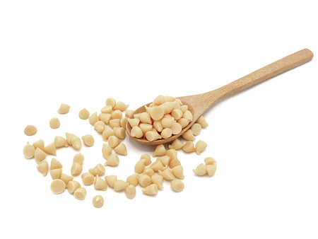 White chocolate chips with wooden spoon on white background.の写真素材