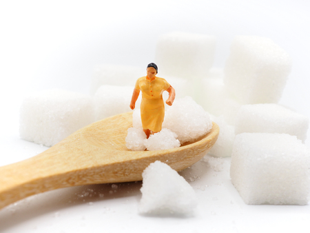Miniature fat woman with sugar on white background,  Healthy lifestyle concept.の写真素材