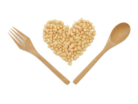 White chocolate chips with wooden spoon on white background.の写真素材