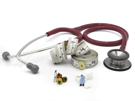 Miniature fat and thin woman with stethoscope, sugar and measuring tape on white background,  Healthy lifestyle concept.の写真素材