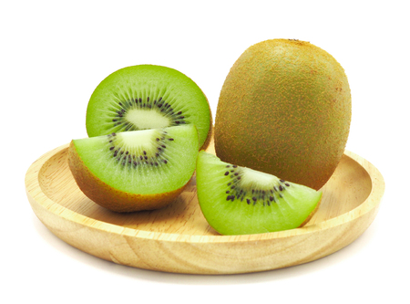 Slice of fresh juicy delicious and healthy kiwi fruit on wooden plate, isolated on white background.の写真素材