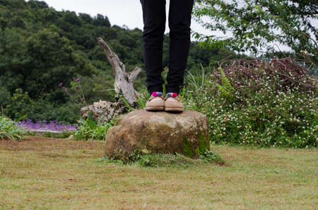woman wear black pants standing on the rock in the gardenの写真素材